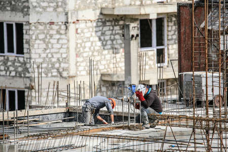 The welder working hard and welds a metal construction in the siteの写真素材