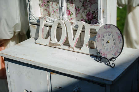 Design elements for wedding: love from wood near vintage clock on the white tableの写真素材