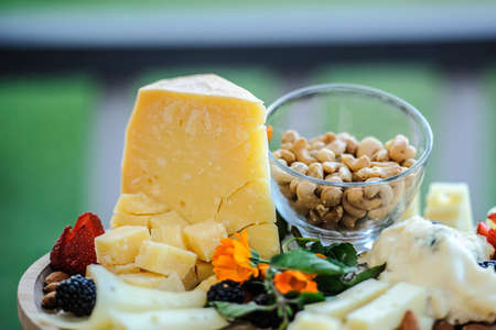 Close up of cheese parmigiano, nuts cashew, strawberry and blackberriesの写真素材