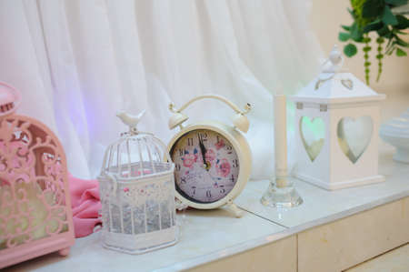 Wedding decoration with pink elements, watch, bird cage, candleの写真素材