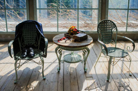 Wedding decorations with jacket and groom's shoes, the table two chairs at the windowの写真素材