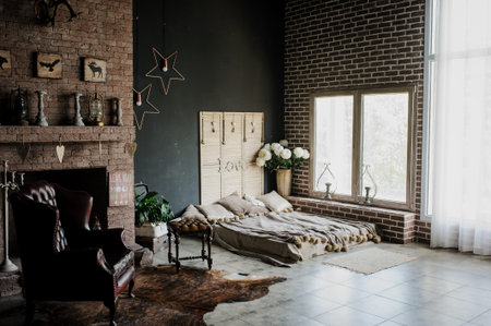 A bed  and a armchair in rustic setting to a wall decorated with plantsの写真素材