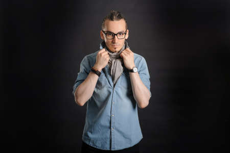 Young handsome boy in denim shirt and glases, curly hair, 
with black backgroundの写真素材