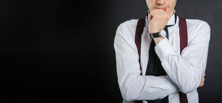 Young handsome boy in white shirt with tie, couse view, clock on hand,with black background