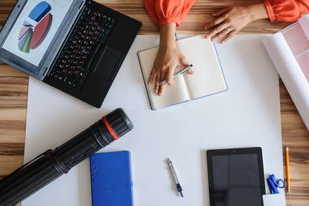 A office desk with architecture project and working hands, top viewの写真素材