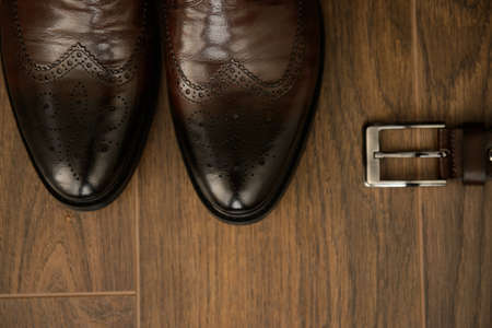 A  groom's shoeson and belt on the wooden floor, up viewの写真素材