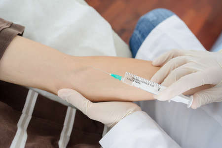 The doctor is injecting to patient in vein, close viewの写真素材
