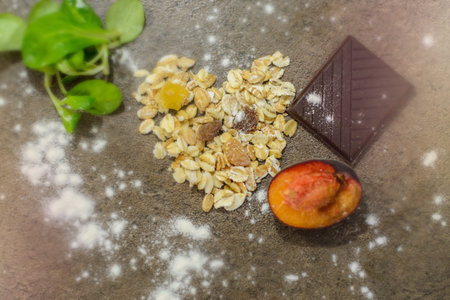 A chocolate, cerels, some fruits and salad leaves on a table, close view