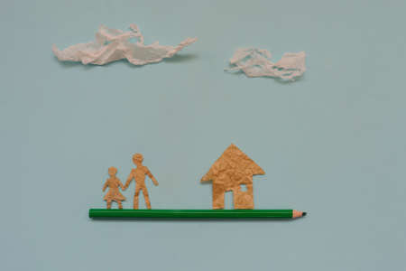 Small people made of paper, living on a pencil, top view, blue backgroundの写真素材