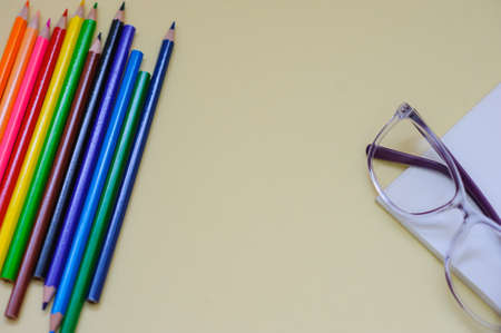 Some colored pencils with instruments to drow, top view, on a beige backgroundの写真素材
