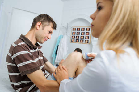 The male pacient at ultrasonography examination at the knee, close viewの写真素材