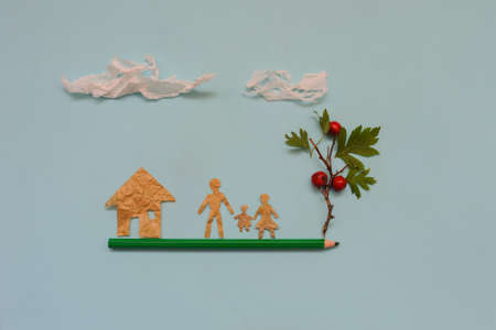 Small people made of paper, living on a pencil, top view, blue backgroundの写真素材