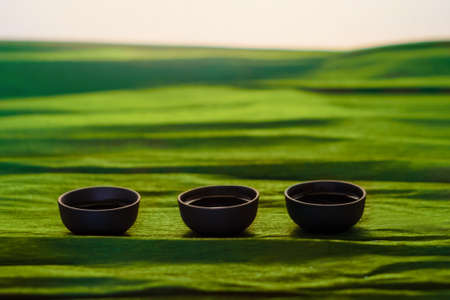 Three cups of ceramics on the green background, close viewの写真素材