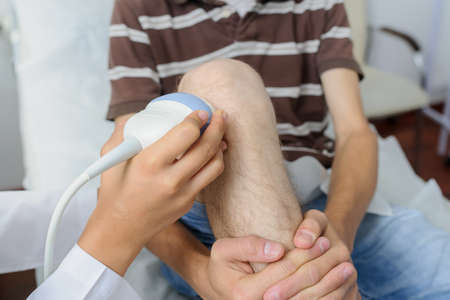 The male pacient at ultrasonography examination at the knee, close viewの写真素材