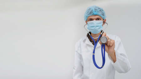 The doctor with the masck and stethoscope in hand, close viewの写真素材