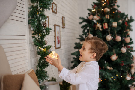a 6-year blond boy with chrismas lights in his hand in a christmas environment