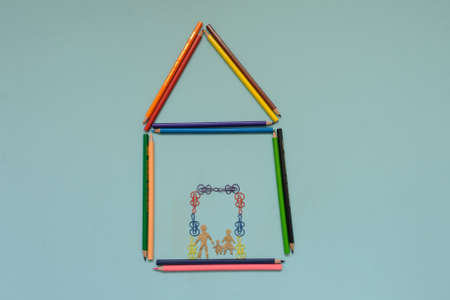 A house maden with colored pencils, blue background, top viewの写真素材