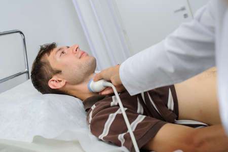 The male pacient at ultrasonography examination at the neck, close viewの写真素材