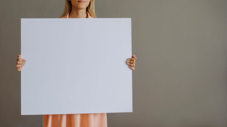 A pretty blonde girl with a whiteboard, close view, grey background