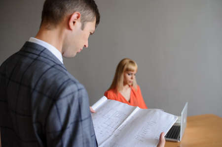 A business woman at a office desk and man looking at the projectの写真素材