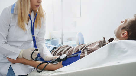 The lady doctor is consulting the patient with stethoscope at his hand, close viewの写真素材
