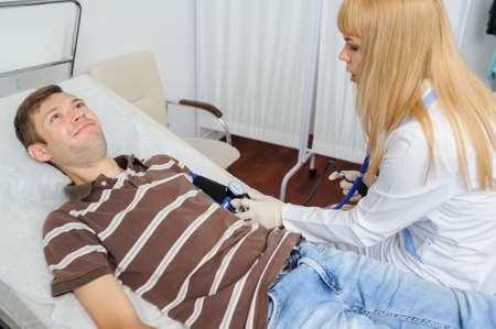The lady doctor is consulting the patient with stethoscope at his hand, close viewの写真素材