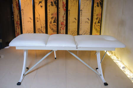 Frontal view of a empty massage bed with towels in the spaの写真素材
