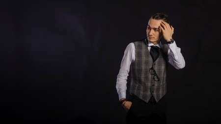 The handsome caucasian young man in a white shirt and suit standing, black backgroundの写真素材