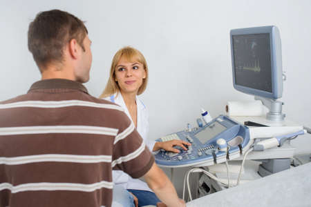 The lady ultrasunography doctor is explaining to the patientat divice, in medical officeの写真素材