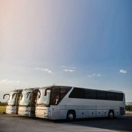 Three buses staying in the parking lot. Front view of the buses with blue sky and clouds.の写真素材
