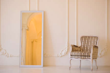 Cozy chair in the photo studio with wedding decoration and flowers bouqet. White walls and sofa with stripes.の写真素材