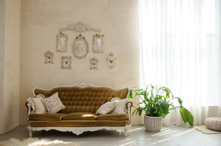 Sofa and chair in the wedding decor studio. One sofa and one chair with flowers and frames on the wall.の写真素材