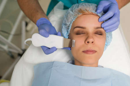 closeup of a woman getting facial ultrasound cleaningの写真素材