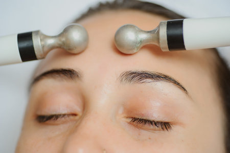 Top macro close up view of women facial massage spa procedure. Electric stimulation facial skin...