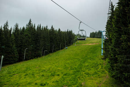 Cable car strings of a teleferic over a green mountainの写真素材