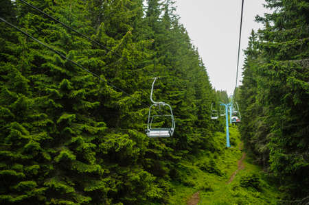 Cable car strings of a teleferic over a green mountainの写真素材
