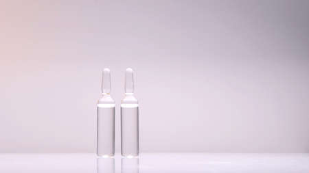 two ampoules with medicine on a white-pink backgroundの写真素材