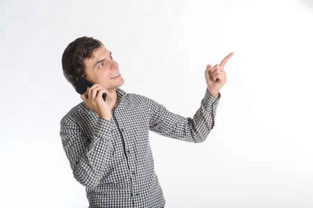 30-years brunet man in a grey outfit on a white background talking on the cell phoneの写真素材