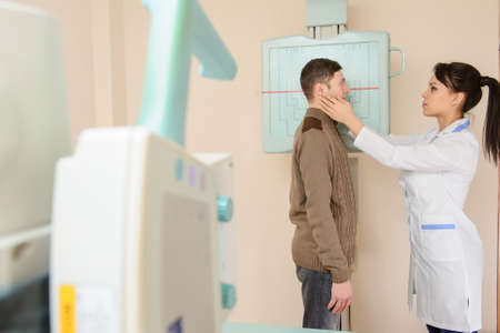 Female doctor preparing the patient for paranasal sinuses or nasal bones x-ray/radiography procedure in the radiologist's cabinetの写真素材