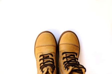 top view of a pair of yellow leather child shoes on a white backgroundの写真素材