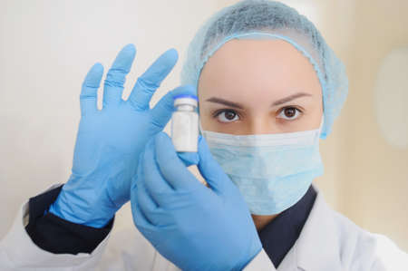Female Doctor holding a vial of white drug powder antibiotics/ penicillin in hospital laboratory room.の写真素材