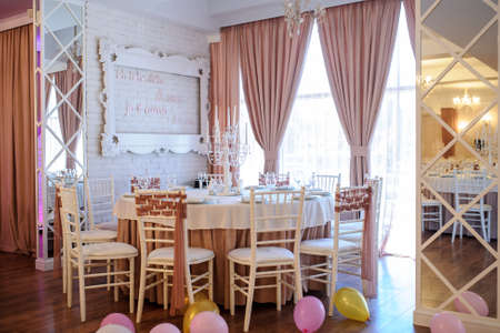 close up photo of a table in a banquet hall in white and brown colors decorated for the eventの写真素材