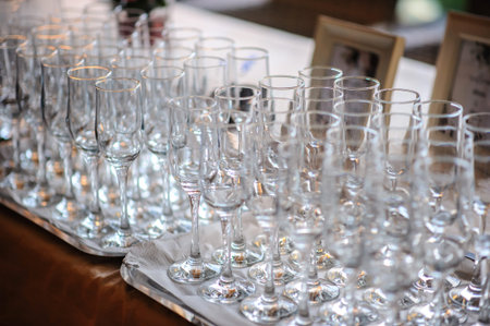 close up photo of rows of empty glasses for champagne on the table