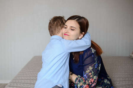 close up photo of a boy hugging his happy motherの写真素材