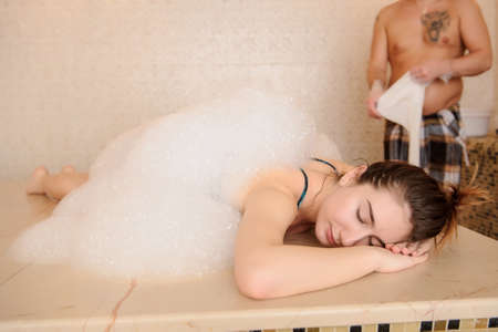 Young woman in white foam relaxing in a hamamの写真素材