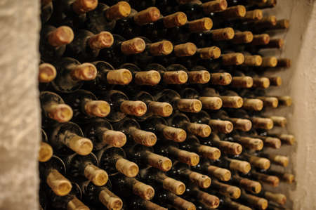 Wine bottles stacked up in old wine cellarの写真素材