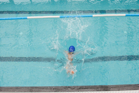 top view of a 7-year boy playing and swimming in the swimming poolの写真素材