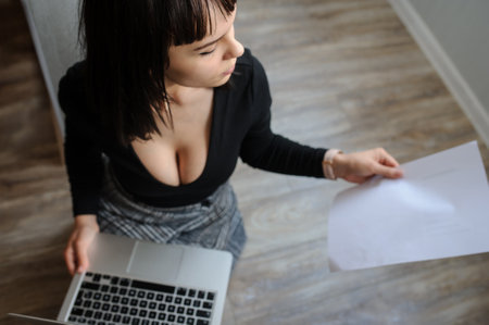 top view of a hot brunete in office outfit sitting on the floor and working on computerの写真素材