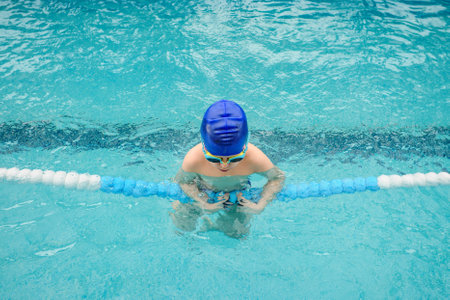 top view of a 7-year boy playing and swimming in the swimming poolの写真素材
