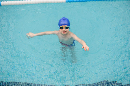 top view of a 7-year boy playing and swimming in the swimming poolの写真素材